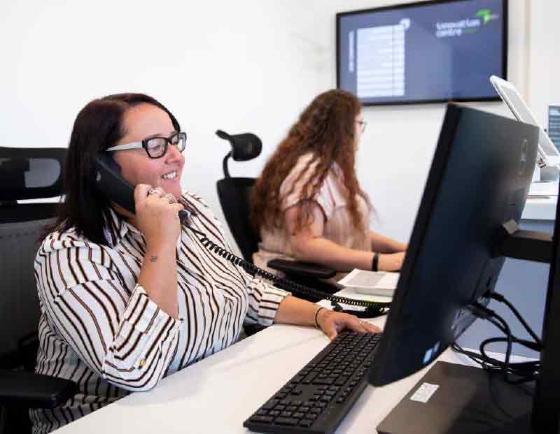 Woman using computer and on the phone in workspace